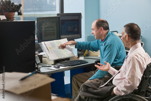 Two businessmen in an office, one with Friedreich's Ataxia and another with spinal cord injury photo