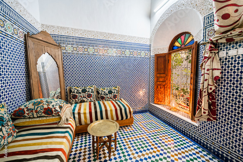 Beautiful traditional Moroccan salon with colorful mosaic tiles inside an old guest house in Morocco