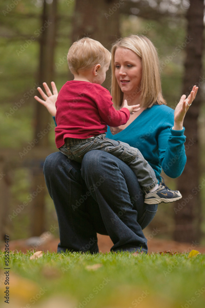 Woman signing the phrase 'All Done' in American Sign Language while communicating with her son