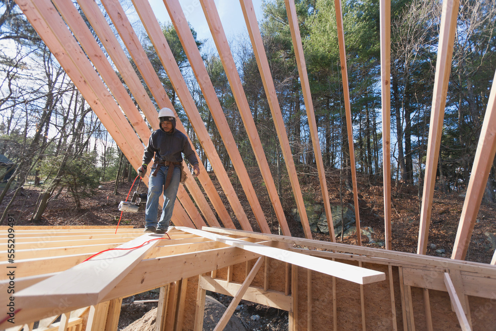 Carpenter walking on a rafter on floor joists Stock Photo | Adobe Stock