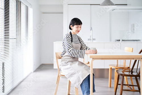 Tableau sur toile エプロン姿で休憩する若い女性