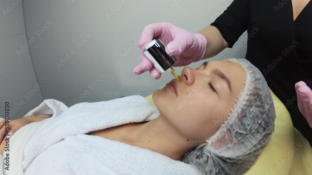 The esthetician applied the serum to the face of a beautiful girl. Hydration of the skin.Beautiful girl in a beauty salon. The beautician puts the cream on the girl's face. The esthetician applied the serum to the face of a beautiful girl. Hydration of the skin.Beautiful girl in a beauty salon. The beautician puts the cream on the girl's face.
