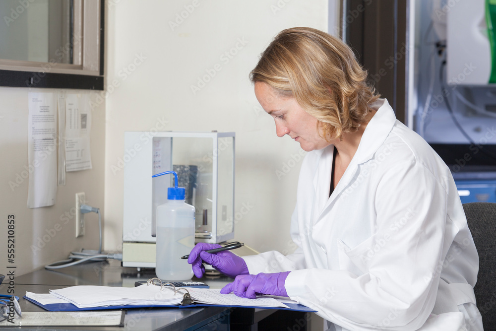 Laboratory scientist recording chemical analysis data in a laboratory