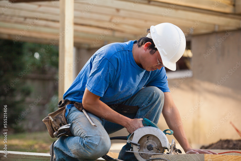 Carpenter cutting deck joist with a circular saw Carpenter cutting deck joist with a circular saw