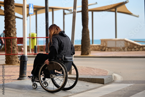 Woman in wheelchair crossing the street in Fuengirola Spain photo