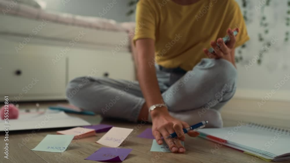 Zoom in of caucasian teenage girl sitting on floor and making notes on flash cards. Shot with RED helium camera in 8K. Zoom in of caucasian teenage girl sitting on floor and making notes on flash cards. Shot with RED helium camera in 8K.