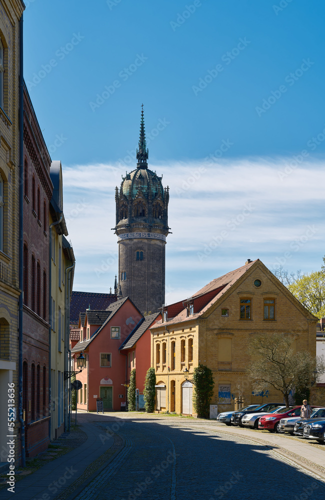Gasse in der historischen Altstadt von Wittenberg. Im Hintergrund der Turm der Schlosskirche