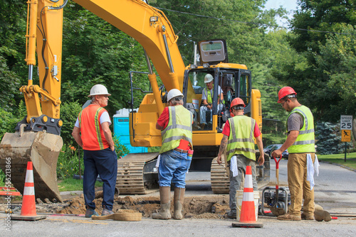 Construction workers digging hole to replace watermain photo