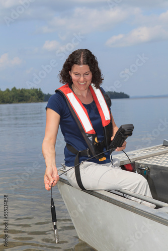 Water treatment engineer using electronic sensor to test water quality
