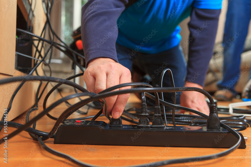 Cable installer putting plugs into power source Cable installer putting plugs into power source