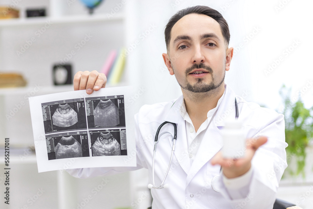 Photo of doctor wearing lab coat showing an ultrasound result to his patient. Photo of doctor wearing lab coat showing an ultrasound result to his patient.
