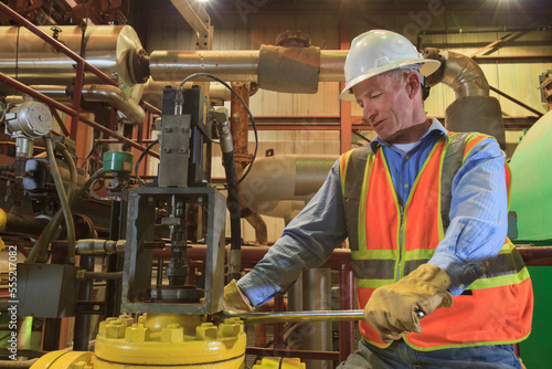 Engineer in electric power plant inspecting condenser piping photo