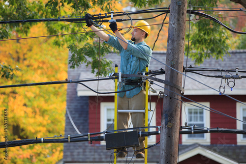 Lineman working on cables at power pole photo