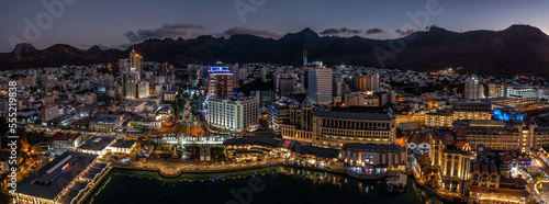 panoramic aerial night view of the old and modern buildings at Waterfront in Port Louis, Capital of Mauritius with mountains in the background. Bird eyes view during nighttime  photo