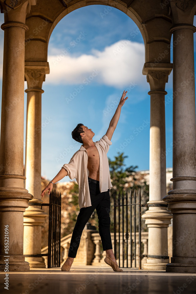 Young man dancing classic ballet in the streets of Barcelona with a beautiful background and light Young man dancing classic ballet in the streets of Barcelona with a beautiful background and light