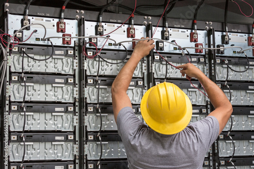 Engineer connecting energy storage batteries for back up power to an electric power plant photo