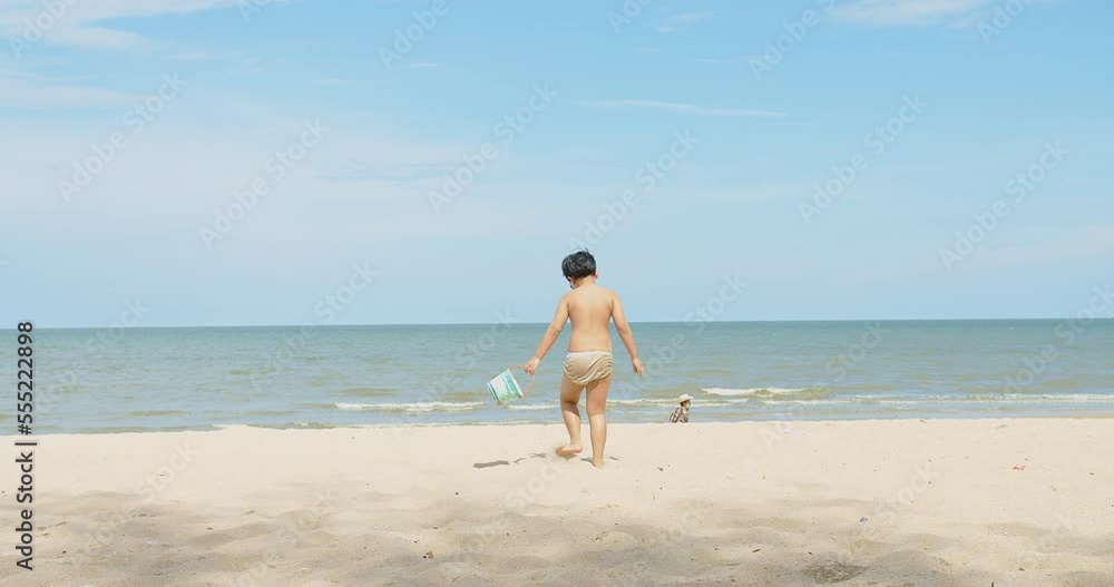 active happy cute Asian children boy enjoy leisure summer vacation holiday travel walking on tropical ocean sea beach and playing sand on sunny day blue sky background active happy cute Asian children boy enjoy leisure summer vacation holiday travel walking on tropical ocean sea beach and playing sand on sunny day blue sky background
