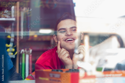 Middle Eastern man with Down Syndrome smiling at work photo