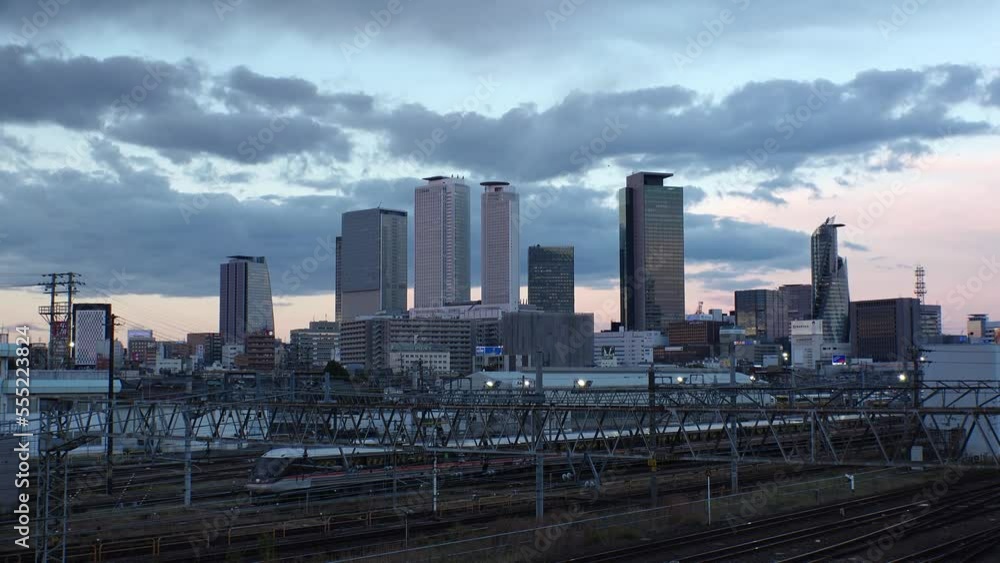 NAGOYA, JAPAN -OCT 2022 : View of office buildings around NAGOYA STATION and railroad in sunset. Time lapse shot, dusk to night. Shot from Koyabashi (bridge). Business and transportation concept video NAGOYA, JAPAN -OCT 2022 : View of office buildings around NAGOYA STATION and railroad in sunset. Time lapse shot, dusk to night. Shot from Koyabashi (bridge). Business and transportation concept video