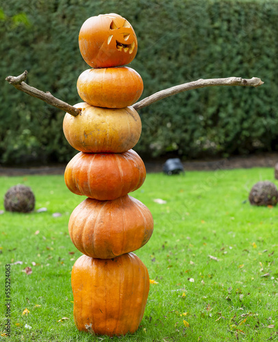 A stack of pumpkins made to look like a man with stick arms and a carved face, VanDusen Gardens; Vancouver, British Columbia, Canada photo