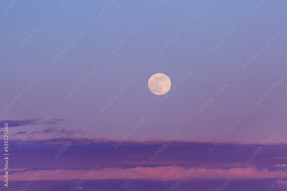 Full moon in a purple sky at dusk with a layer of clouds on the horizon; Surrey, British Columbia, Canada Full moon in a purple sky at dusk with a layer of clouds on the horizon; Surrey, British Columbia, Canada