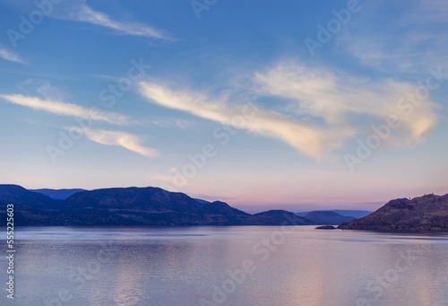 Okanagan Lake at sunset with the silhouetted Coast range mountains along the shoreline and in the distance; Peachland, British Columbia, Canada photo