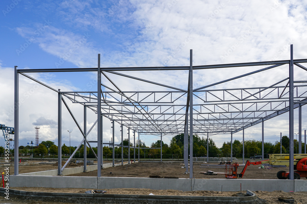 Assembled steel framework of new modern industrial building with foundation concrete panel border Assembled steel framework of new modern industrial building with foundation concrete panel border