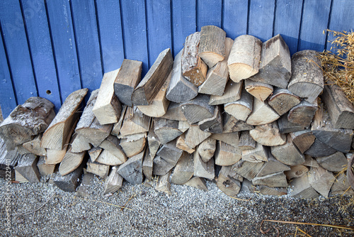 preparation of frewood for the winter. Woodpile against a blue wall. photo