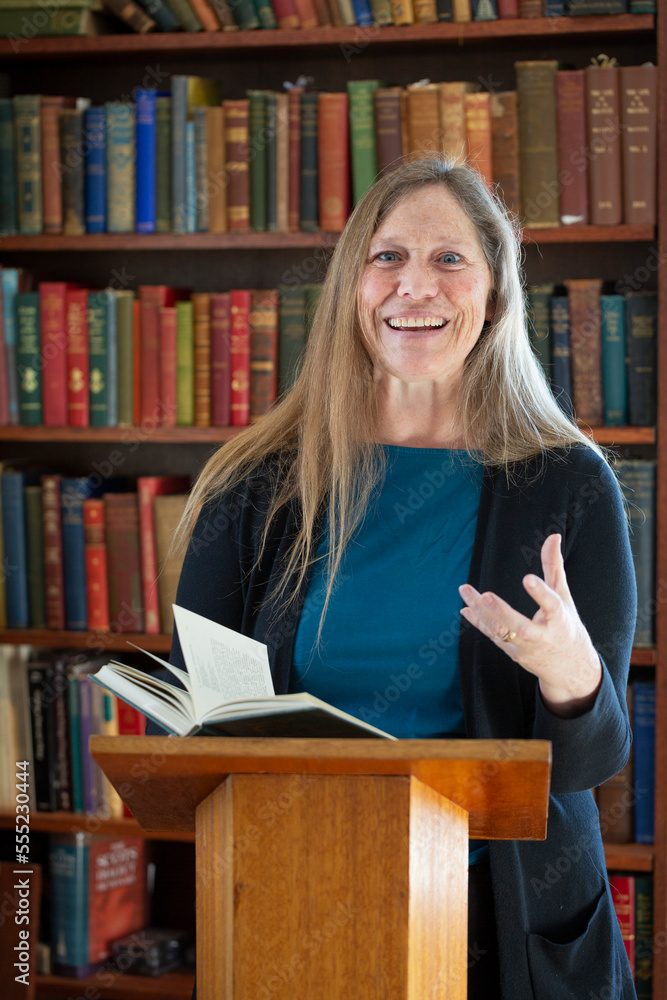 Portrait of a mature woman reading at a podium; Ottawa, Ontario, Canada Portrait of a mature woman reading at a podium; Ottawa, Ontario, Canada