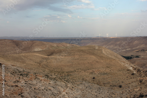 Desert landscape view of sunny rocky cliff with wind turbines in view taken from Shobak Castle, Jordan