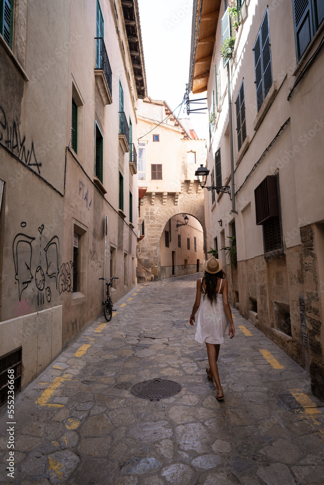 young woman walking through the streets of mallorca