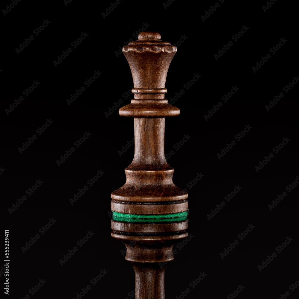 Wooden black chess queen isolated at dark background Wooden black chess queen isolated at dark background