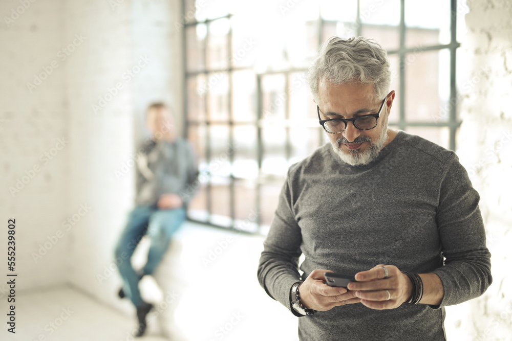 Fototapeta premium man uses a smartphone in a modern office