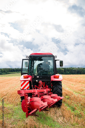 tractor with a large plow is ready to work in the field