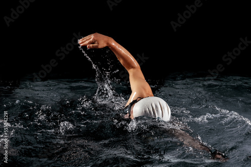 Sportsman swimming with black background (ID: 555242291)