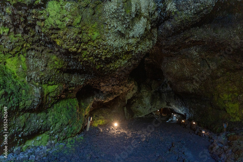 Exploring a volcanic cave in the Volcanic Caves Park at the foot of Villarrica volcano in Pucon, Chile 