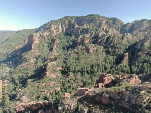 Aerial of Sedona landscape with red sandstone cliffs in pine tree forest