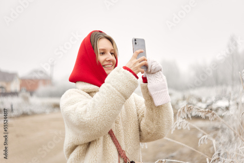 Young woman taking picture outside in winter © Anischenko