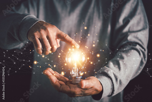 Businessman's hand holding illuminated light bulb with network connection line, New idea creativity concept, Innovation and inspiration for business administration, brainstorming.