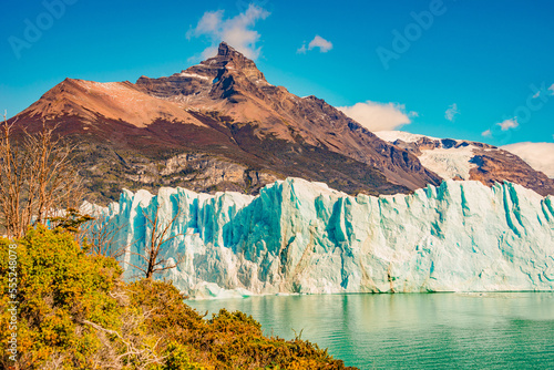 View over big Perito Moreno glacier in Patagonia with blue sky and turquoise water glacial lagoon, South America, Argentina, in Autumn colors photo