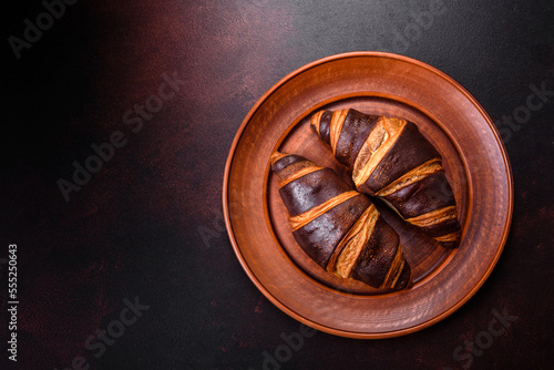 Beautiful tasty fresh crispy croissant on a dark concrete background