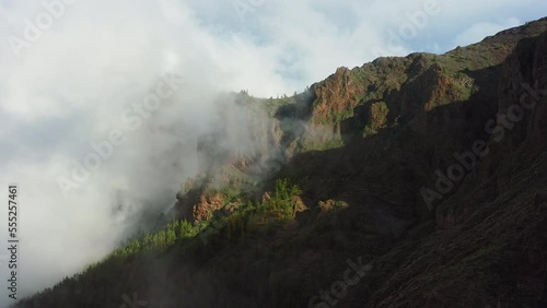 White air clouds descend down the mountainside into the valley. Aerial flying through mist in winter time in Teide Naional Park. Tenerife Canary Islands Spain Europe. photo