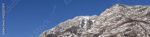 Banner 4:1 with a mountain picturesque landscape against a blue sky