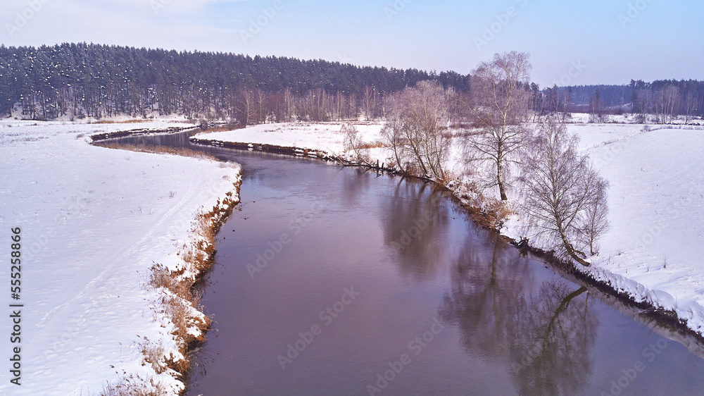 Winter river landscape, snow covered fields. Hoarfrost on trees, plants. Frosty morning. Sunny cloudy Misty weather. Cold season. Calm nature scene.
