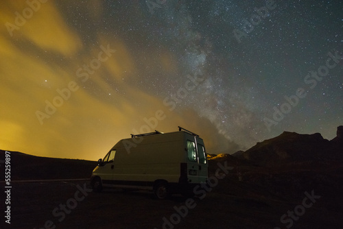 Milky Way in the night sky over camper van in the Pyrenees mountains, Col du Pourtalet, Nouvelle-Aquitaine, France