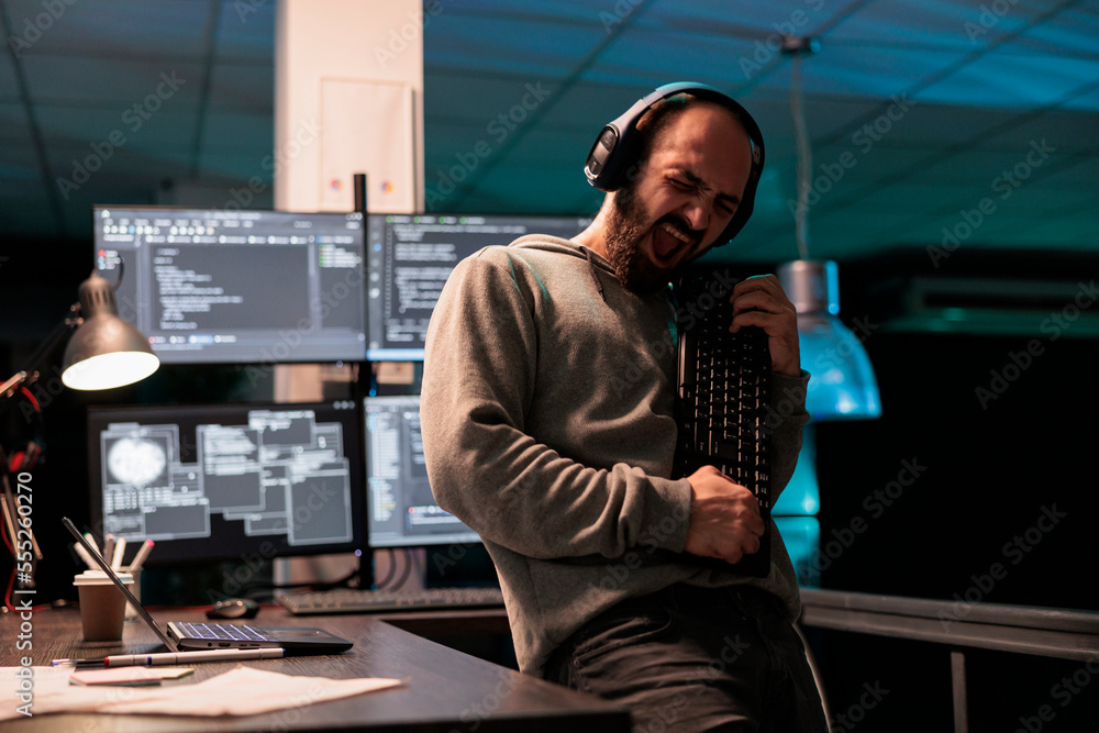 Male software engineer playing guitar with keyboard, writing code with cloud computing and programming html source. Cheerful smiling developer having fun and acting silly in office. Male software engineer playing guitar with keyboard, writing code with cloud computing and programming html source. Cheerful smiling developer having fun and acting silly in office.