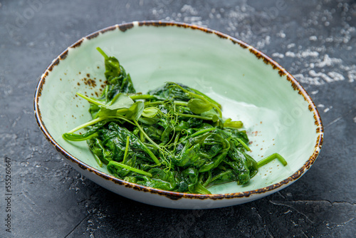 Garnish steamed spinach on grey table side view