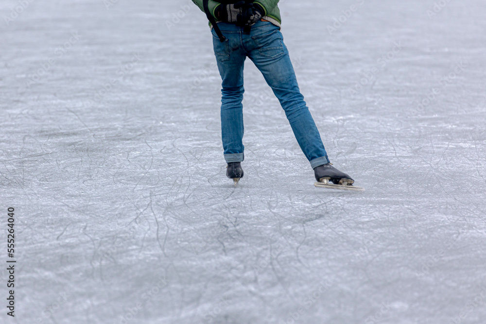 Selective focus of low angle a man legs with ice skates shoes, Nature skating on ice on the lake in winter with soft selective focus, Hobby and leisure activities, Sport and recreation background.