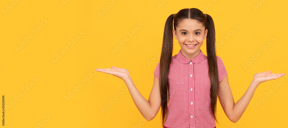 happy child presenting product on yellow background copy space, choice. Child face, horizontal poster, teenager girl isolated portrait, banner with copy space. happy child presenting product on yellow background copy space, choice. Child face, horizontal poster, teenager girl isolated portrait, banner with copy space.
