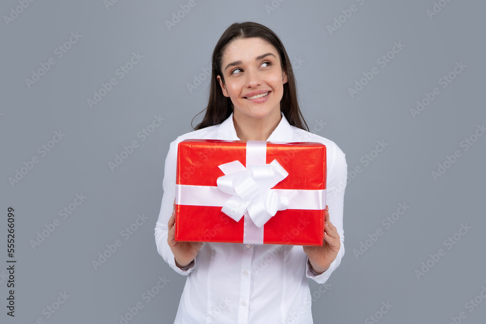 Woman with gift. Portrait of excited young girl holding gift box, isolated grey background. Pretty girl with present. Woman with gift. Portrait of excited young girl holding gift box, isolated grey background. Pretty girl with present.
